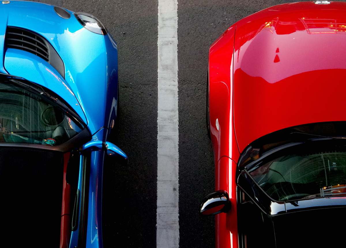 light top view photo of red and blue convertibles on asphalt road car