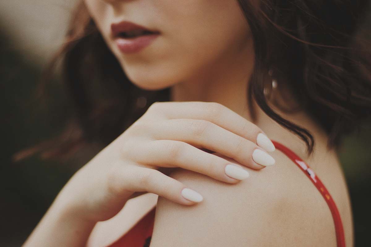 person close-up of woman in red spaghetti strap top finger