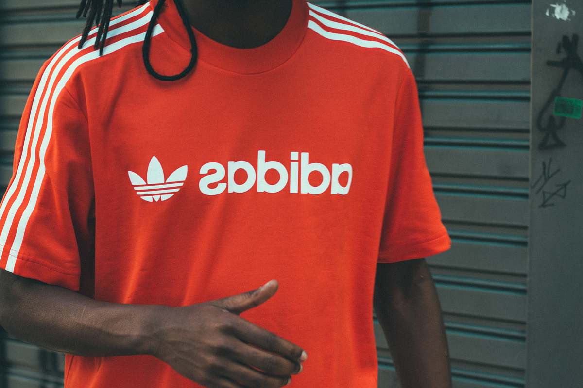 person man wearing red and white adidas crew-neck T-shirt people