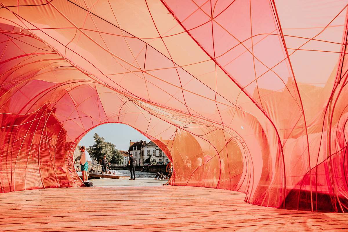 person people walking underneath red cloth path