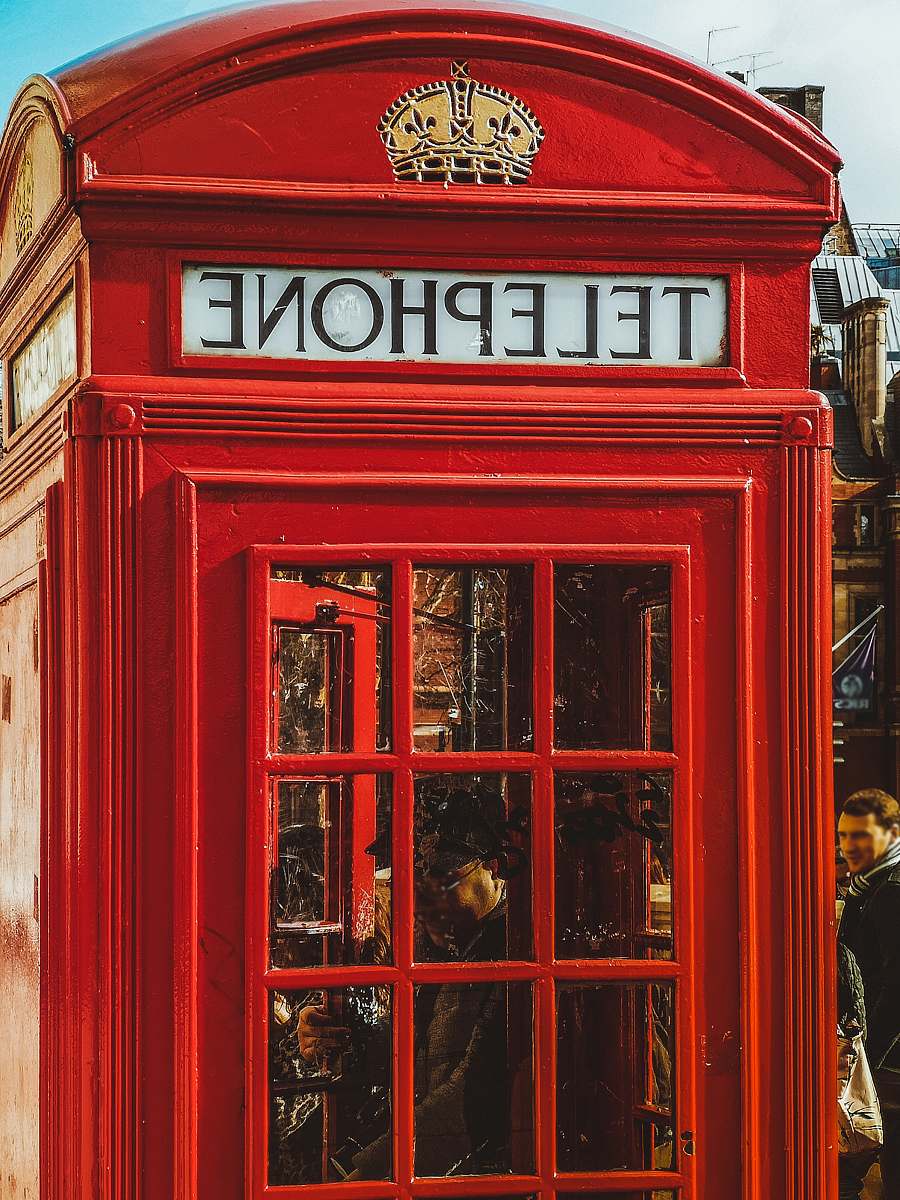 person person inside red telephone booth during daytime phone booth