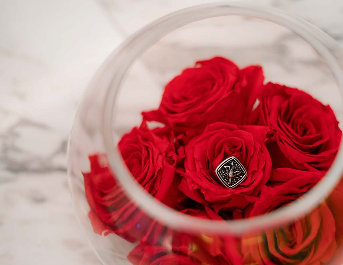 person red flowers in clear glass bowl people