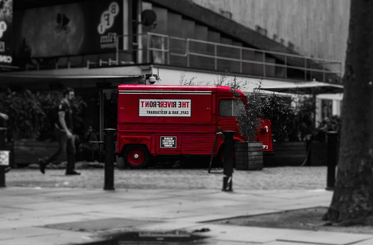 person selective color photo of red van vehicle