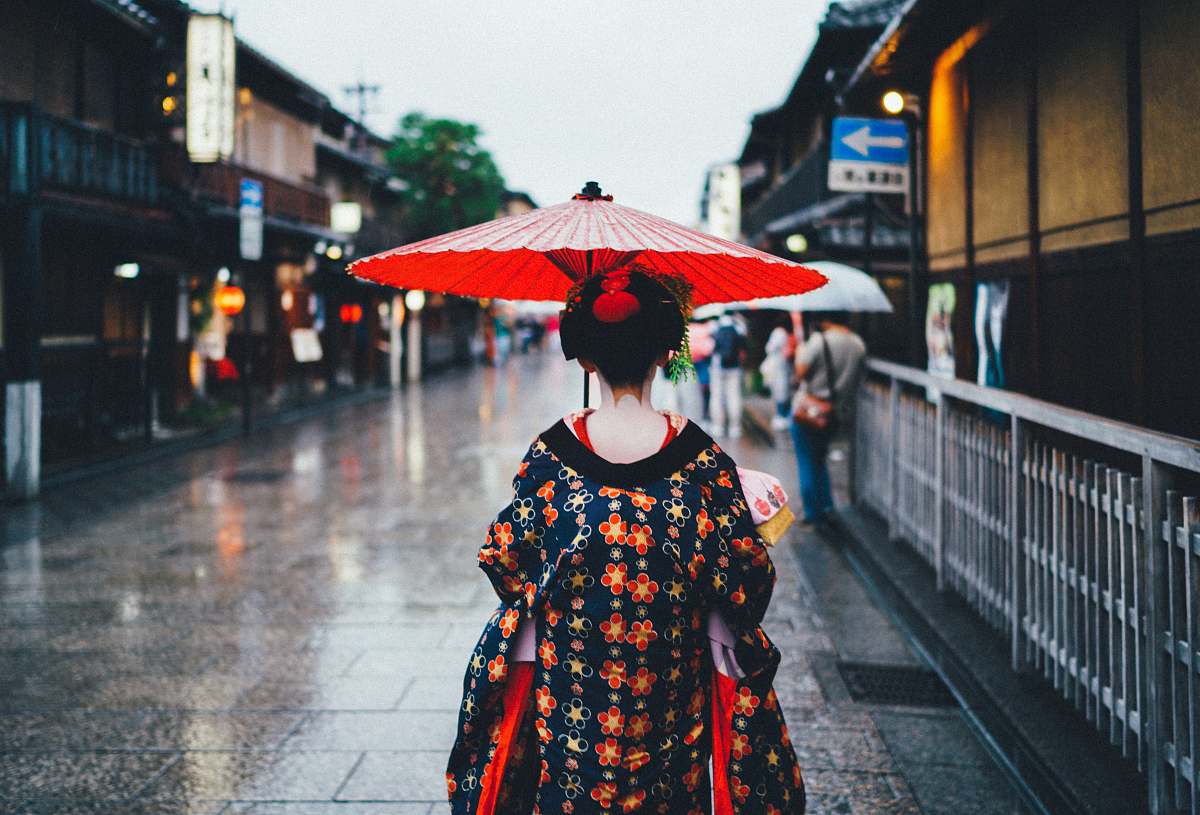 japan woman holding oil umbrella near on buildings people