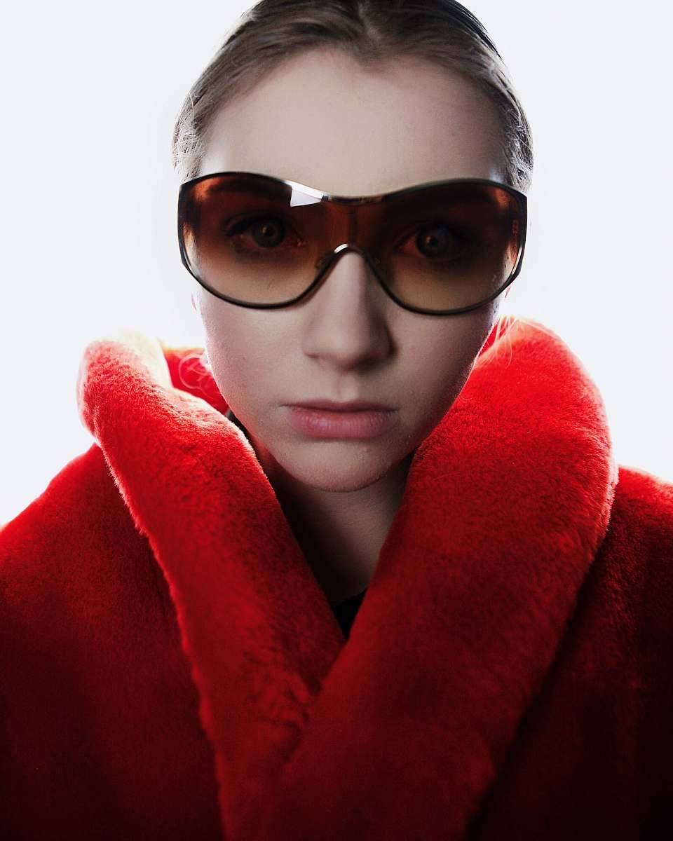people woman in red coat wearing brown sunglasses person