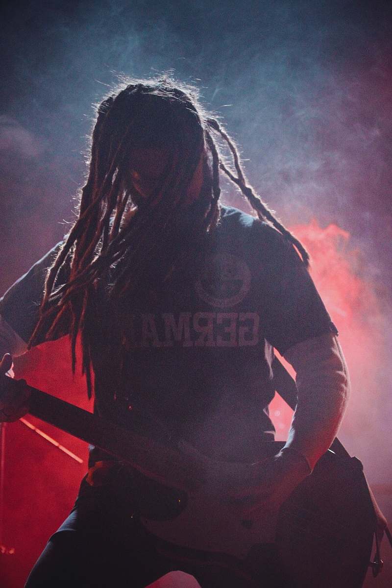 person woman playing guitar on concert people