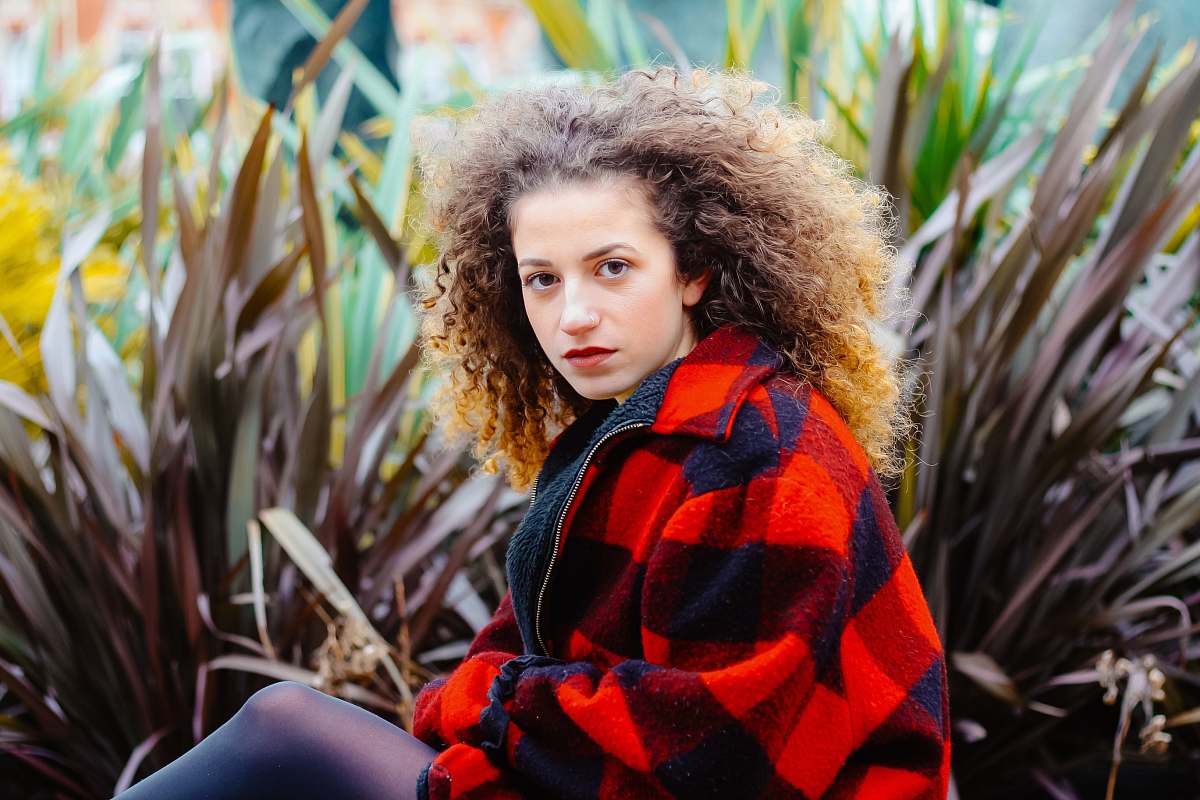 person woman sitting beside black plant people