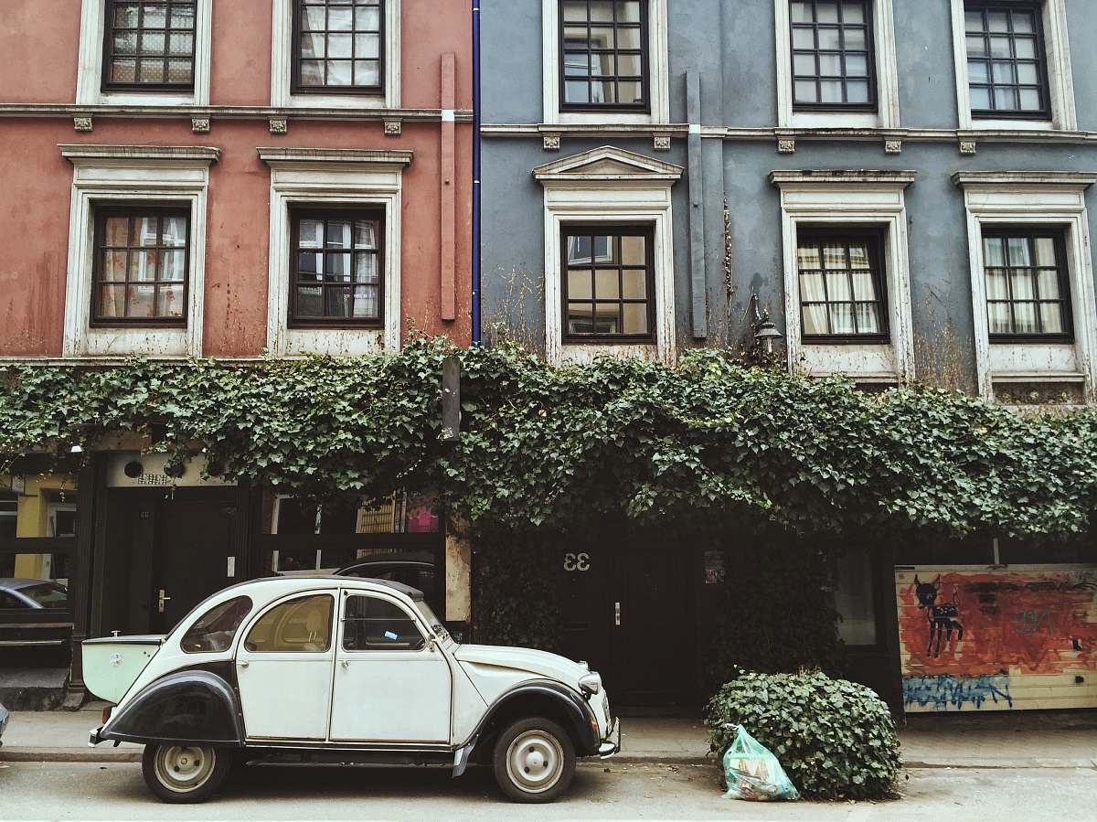 car white car parked beside brown building urban
