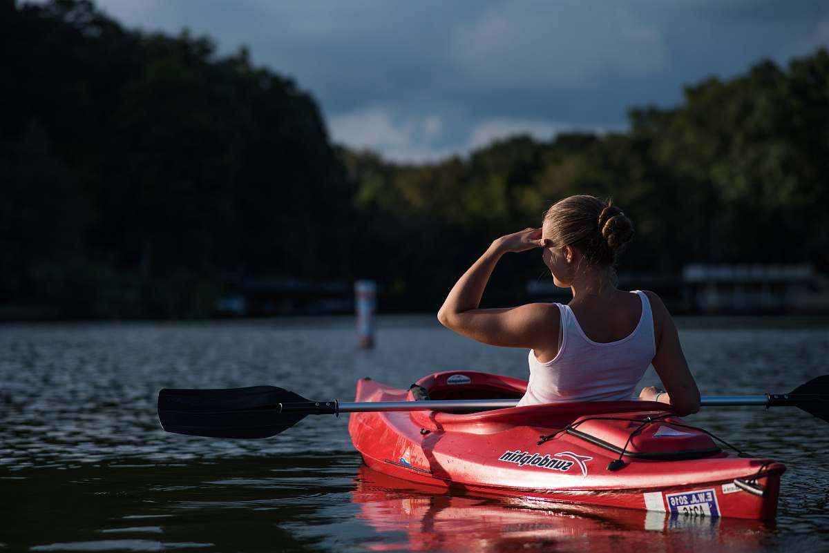 canoe woman looking at the trees while riding on kayak boat