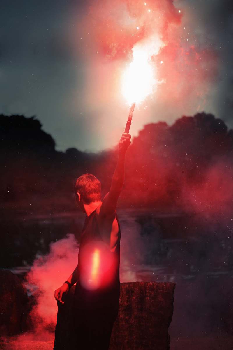 human shallow focus photo of person holding flare flare