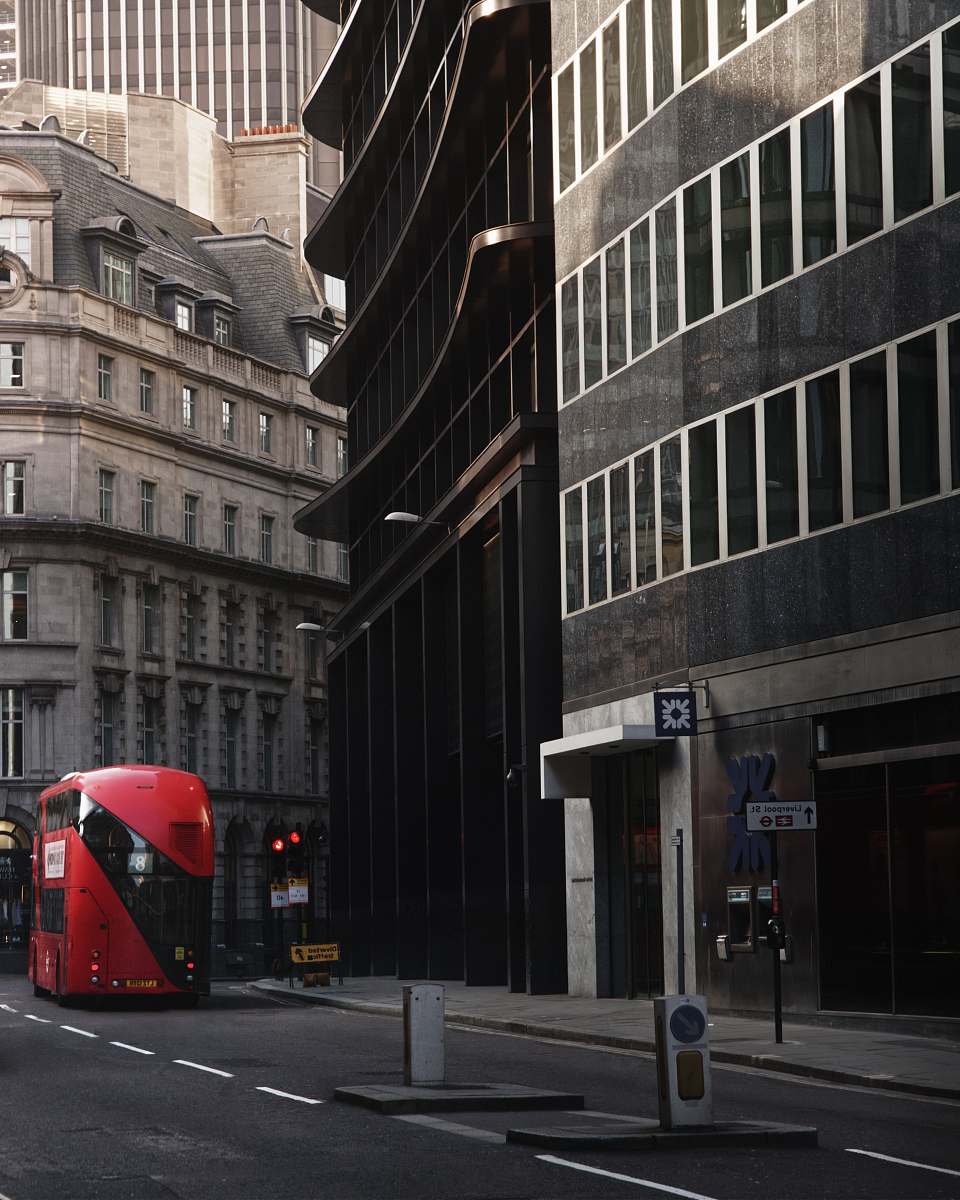 bus red bus in front of black painted building transportation