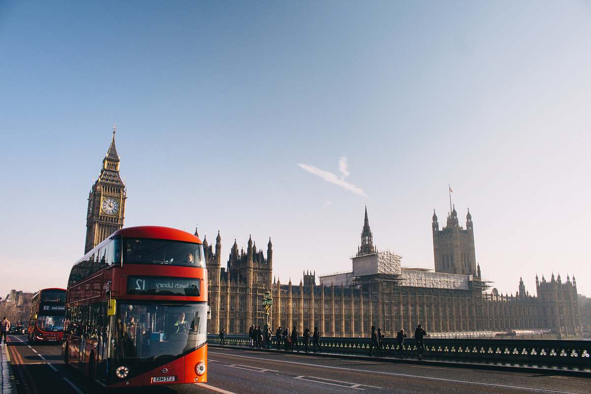 bus red double-decker bus passing Palace of Westminster, London during daytime double decker bus