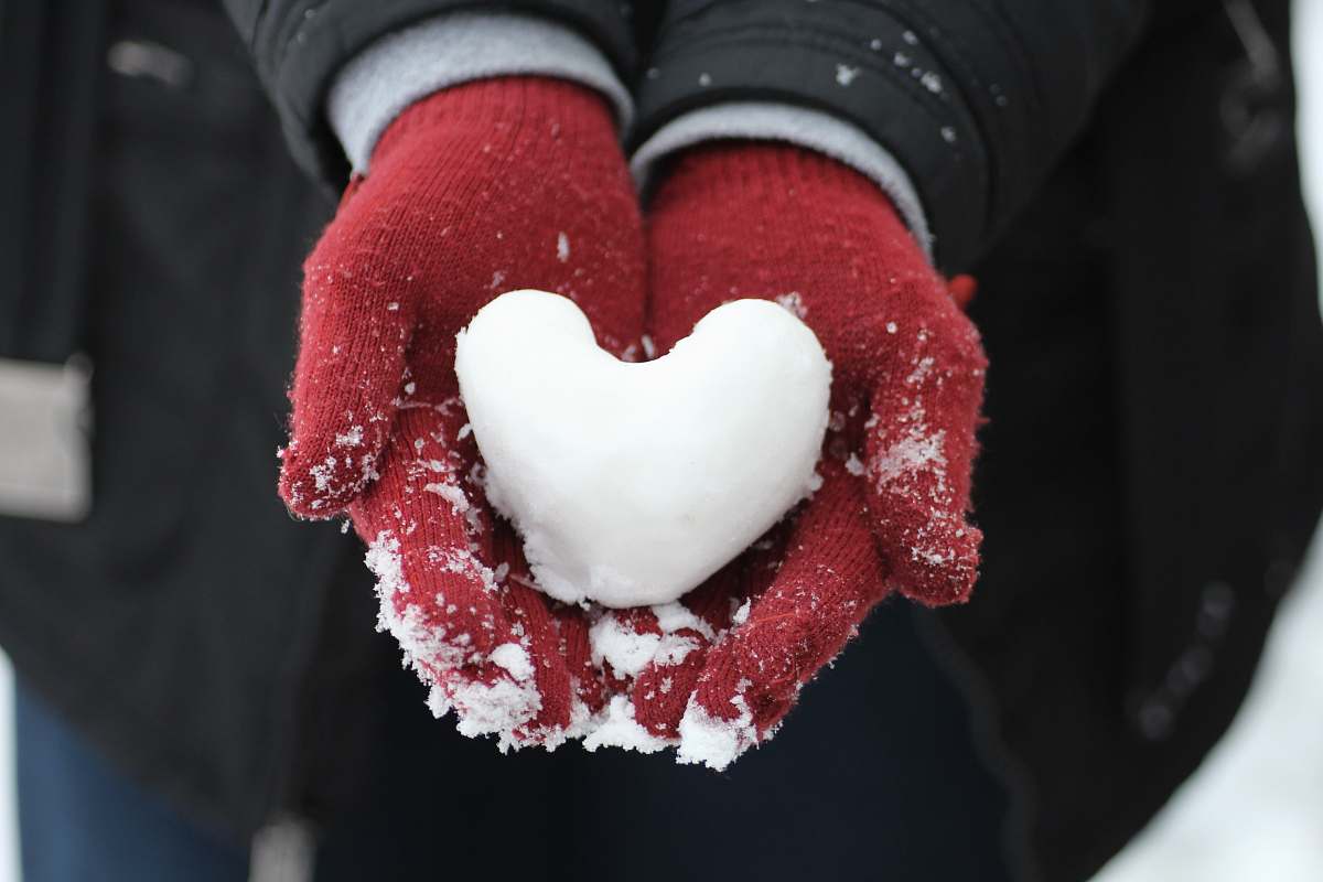 hand person holding heart-shaped snow holding