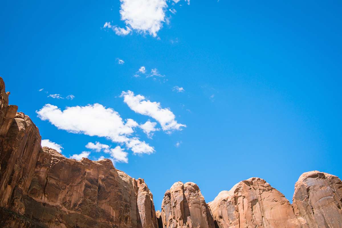 blue brown cliff under white and blue cloudy sky moab