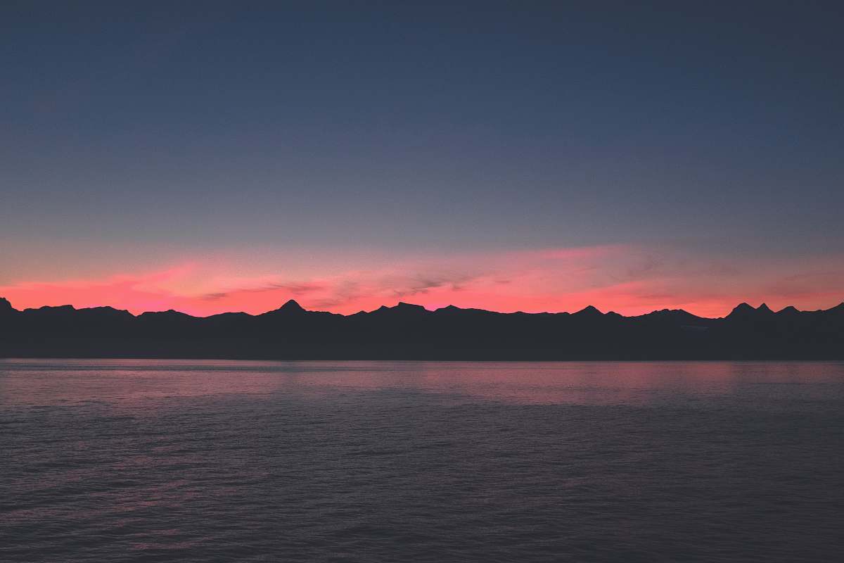 outdoors body of water near mountain during blue hour sunset