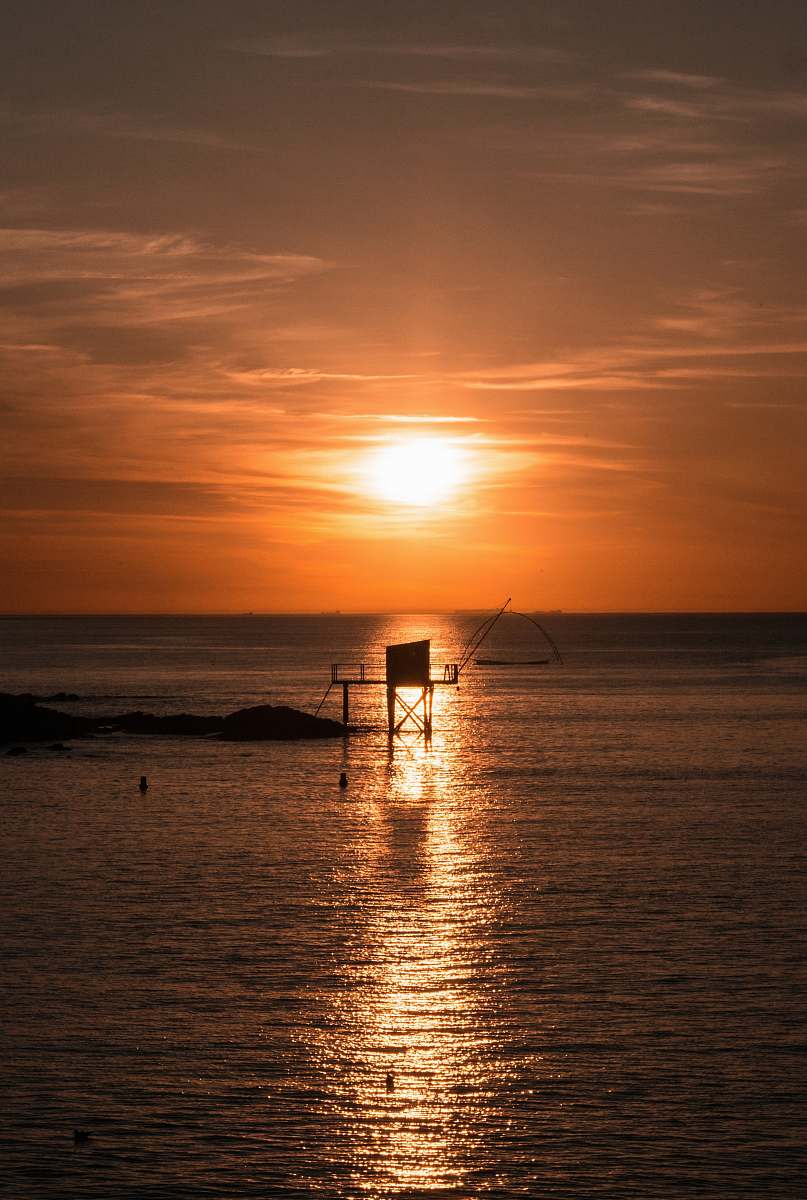 flare silhouette photography of a platform in the sea during golden hour light