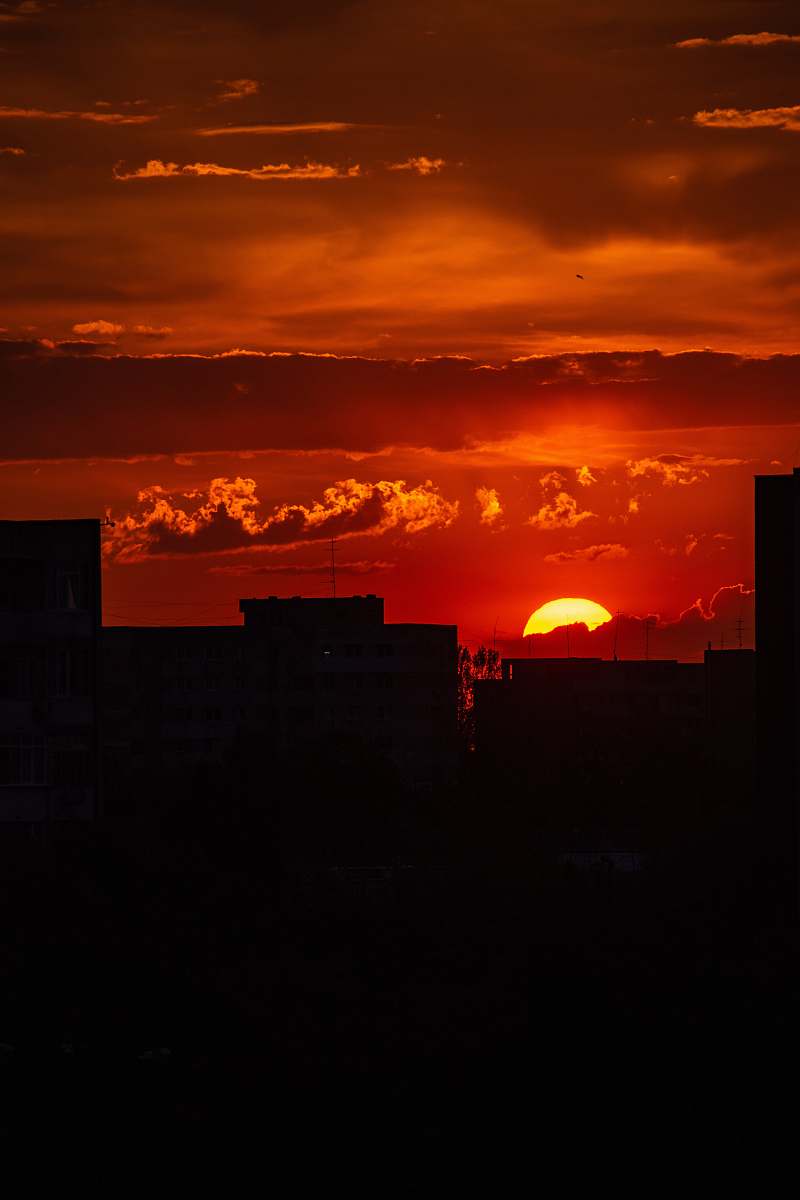 sunset silhouette photography of buildings under cloudy sky during golden hour outdoors