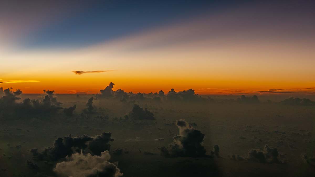 outdoors white and black clouds on the air under golden hour sky