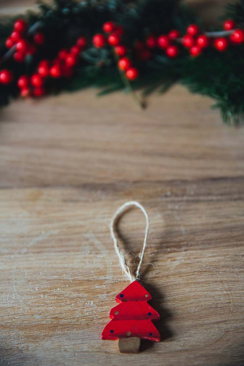 christmas red pine tree hanging decor on brown wood plank jewelry