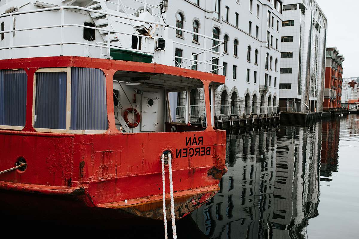 water red boat near white building boat