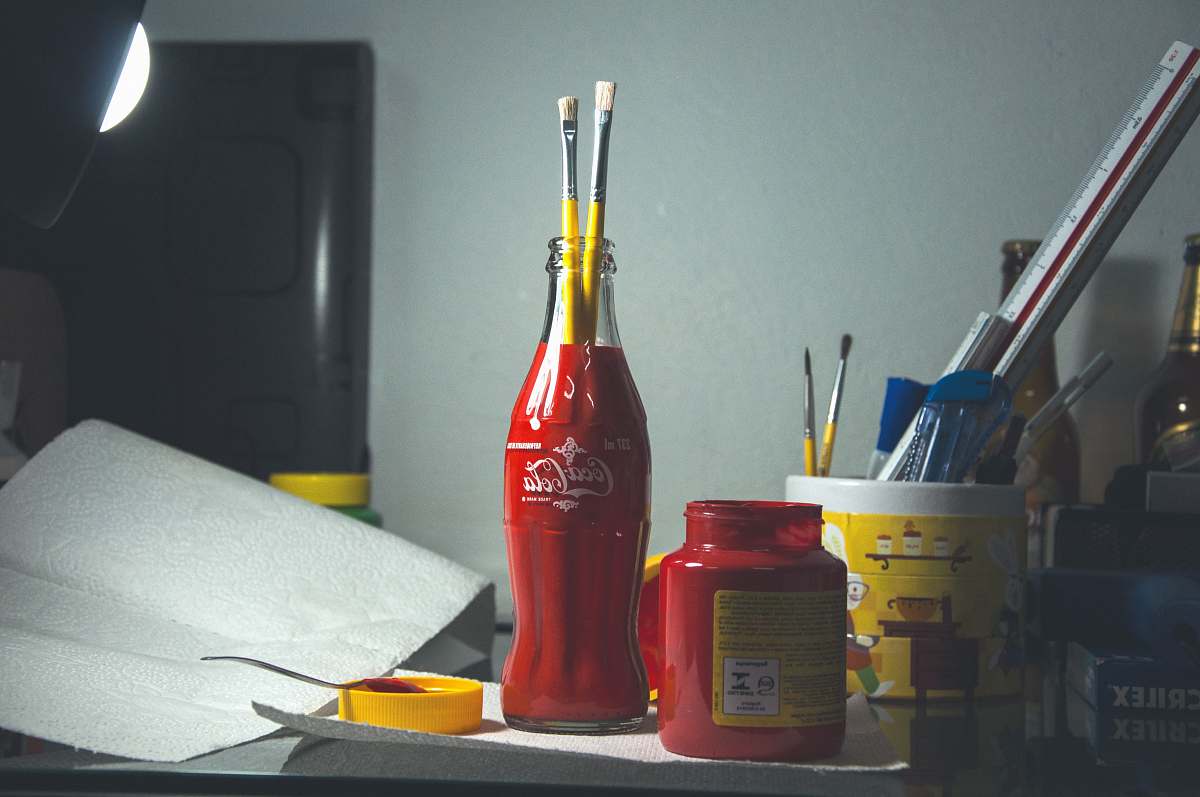 bottle red Coca-Cola glass bottle with paint brushes jar