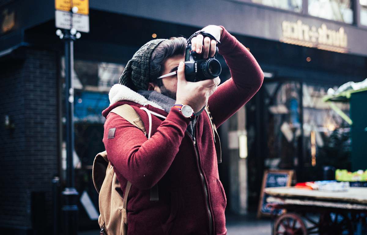 person man taking a photo near storefront human
