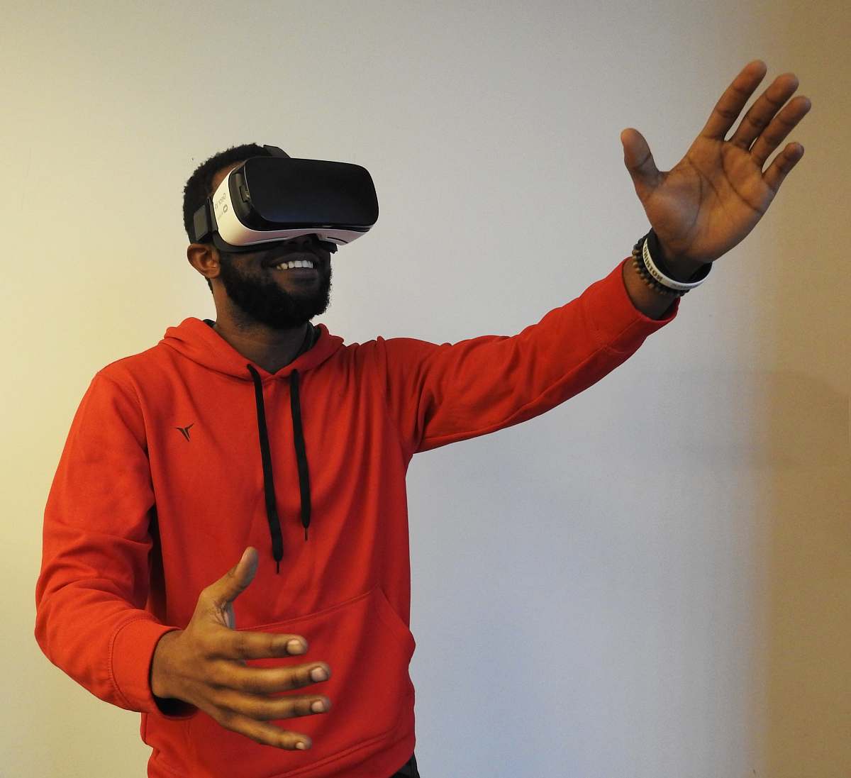 person man wearing white VR headset while lifting right hand human