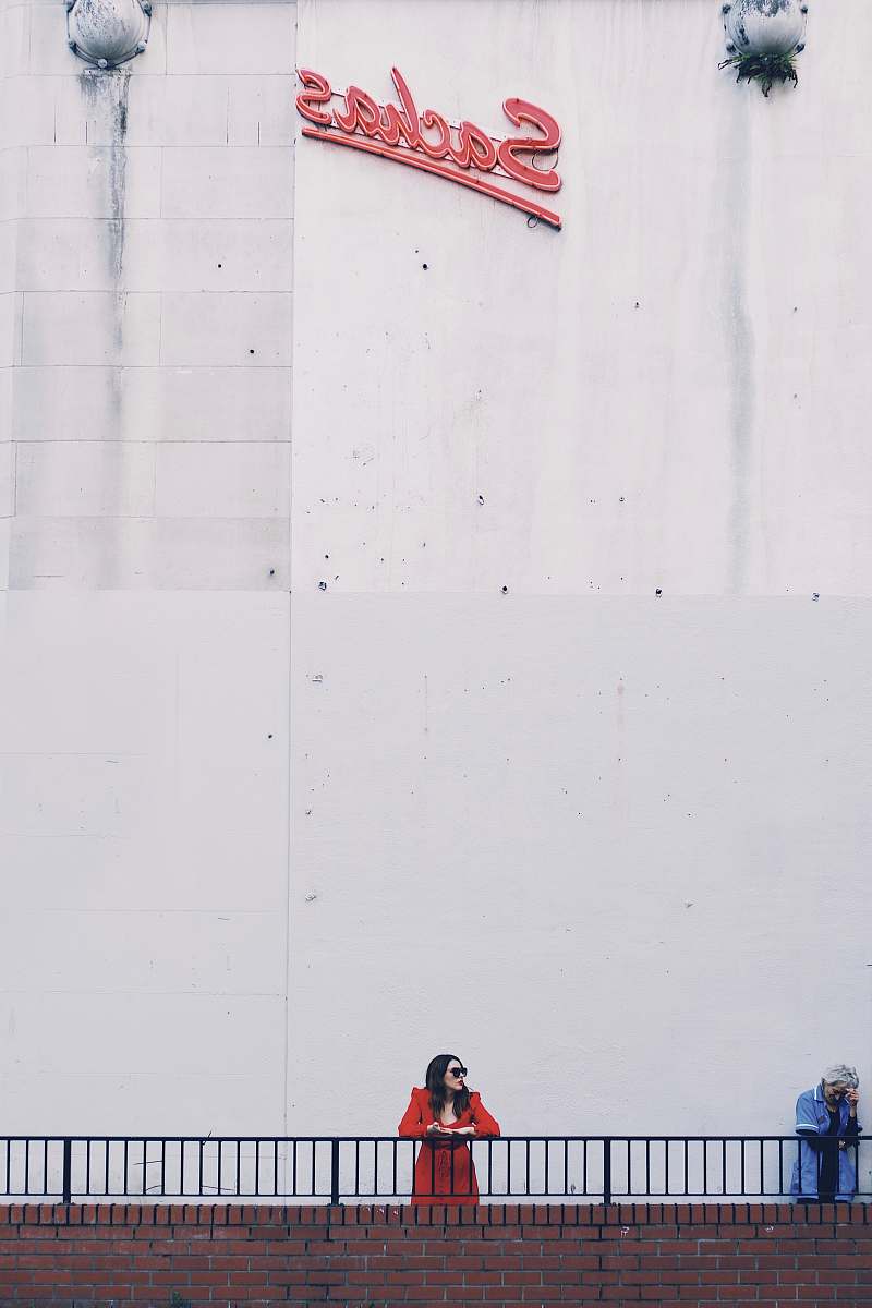 human woman in handrail under Sachas signage person