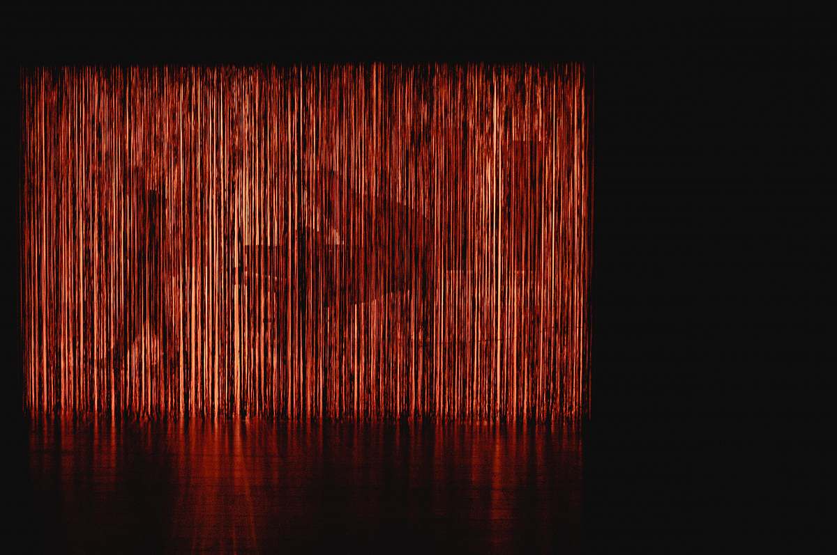 brown grand piano at the back of red LED light curtain