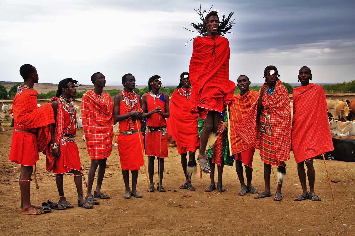 people group of men wearing red suits standing on brown soil tribe