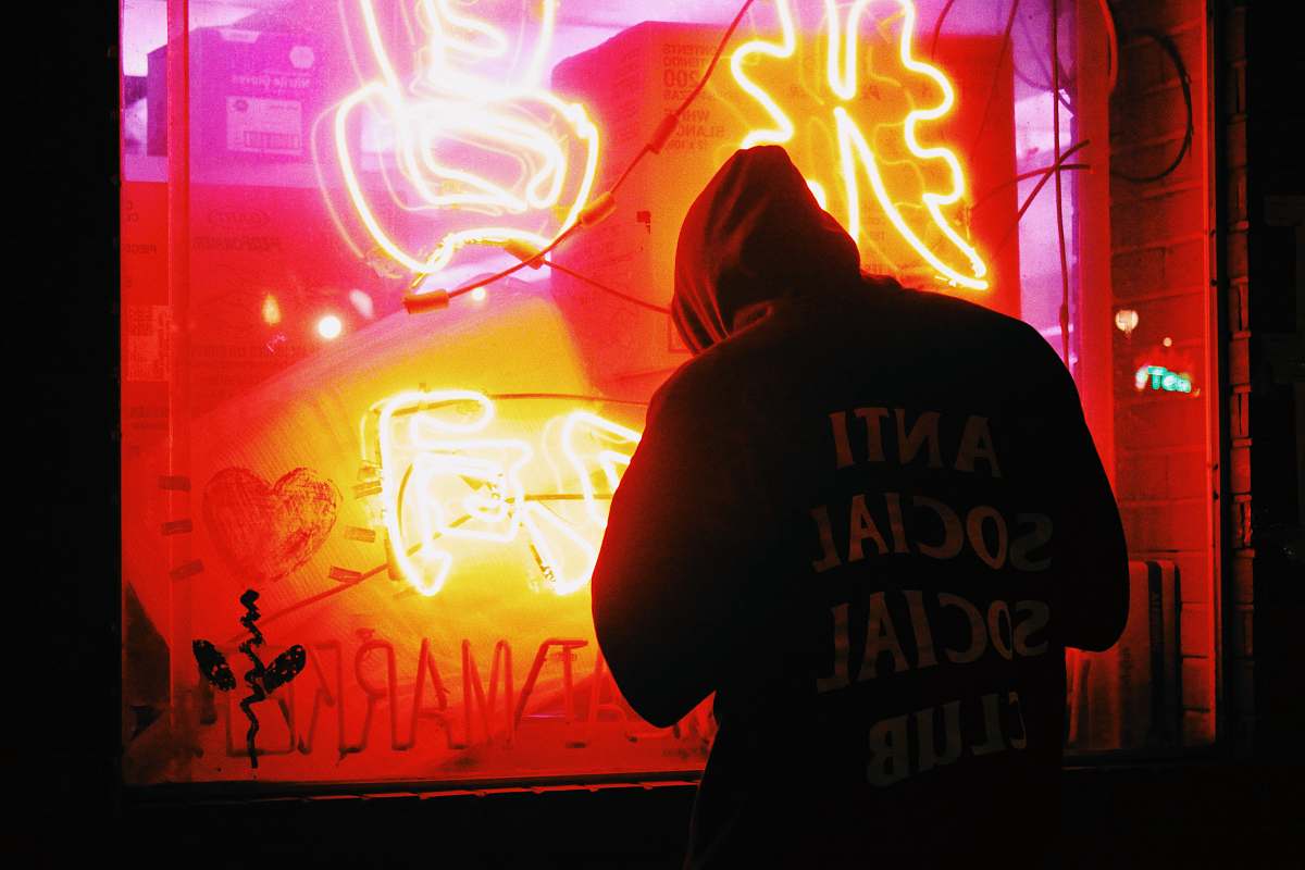 neon man in hoodie looking at the window chinese