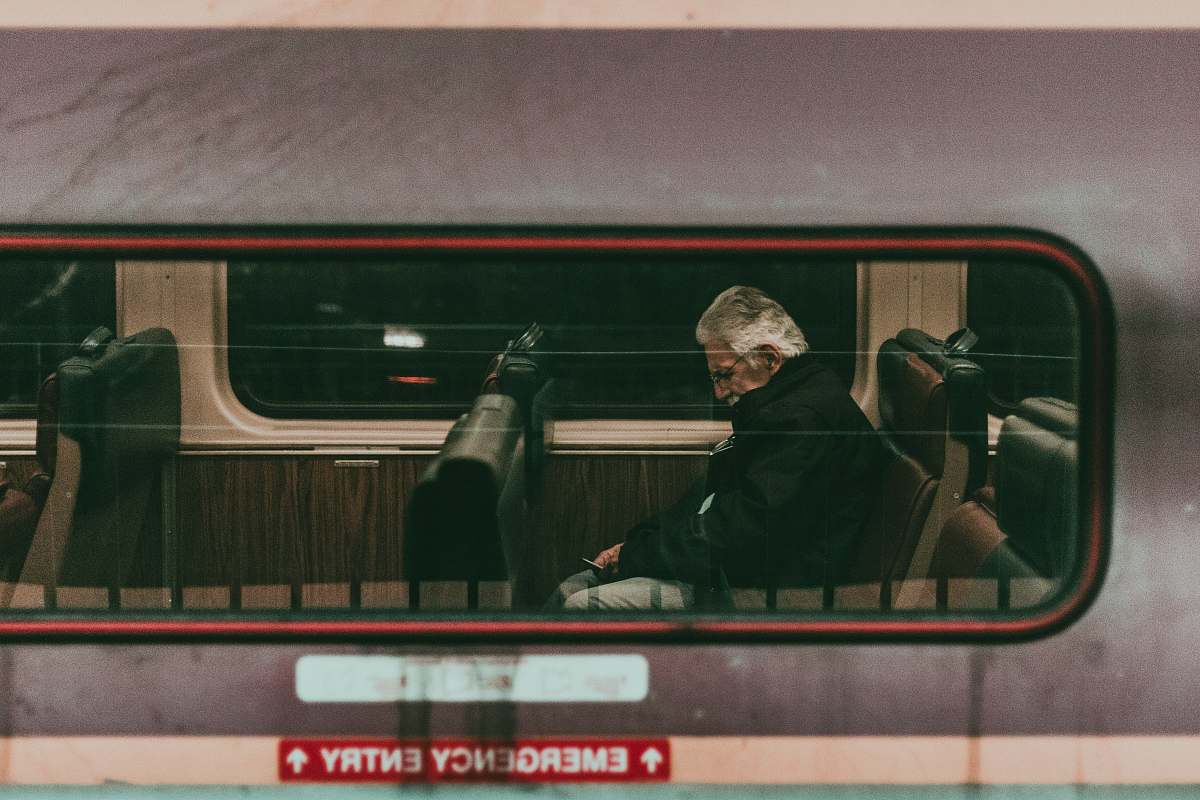 transportation man sitting on train seat human