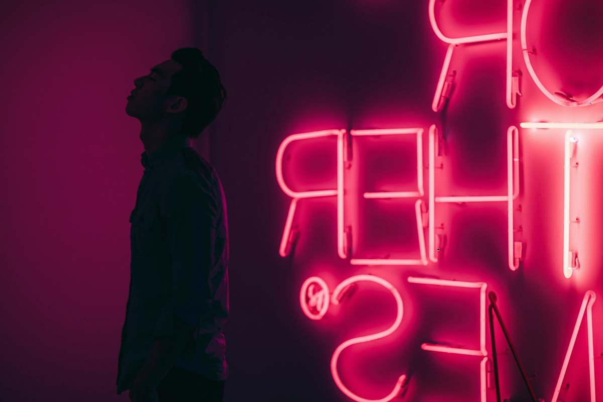 people man standing beside red LED signage human