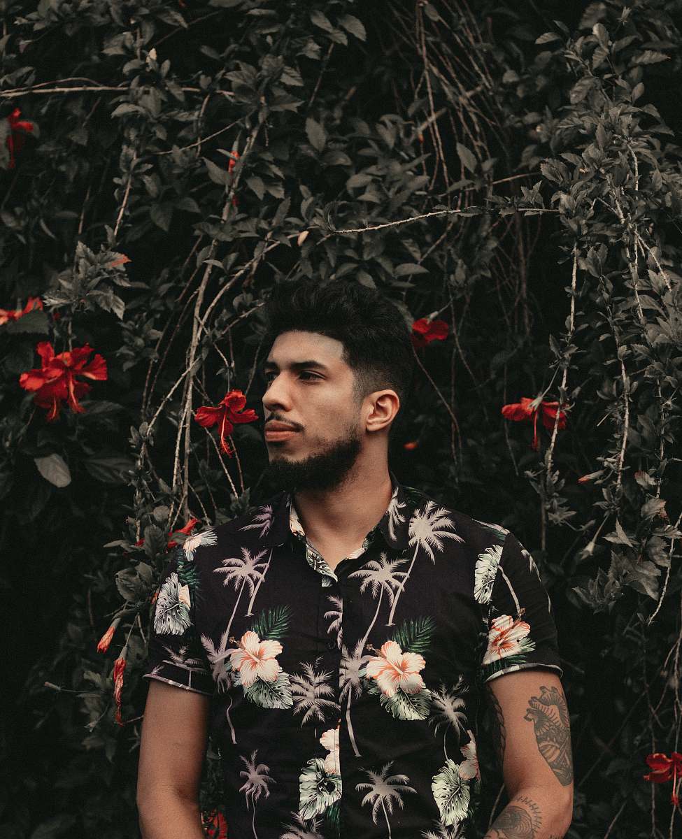 human man standing in front of red flowers people