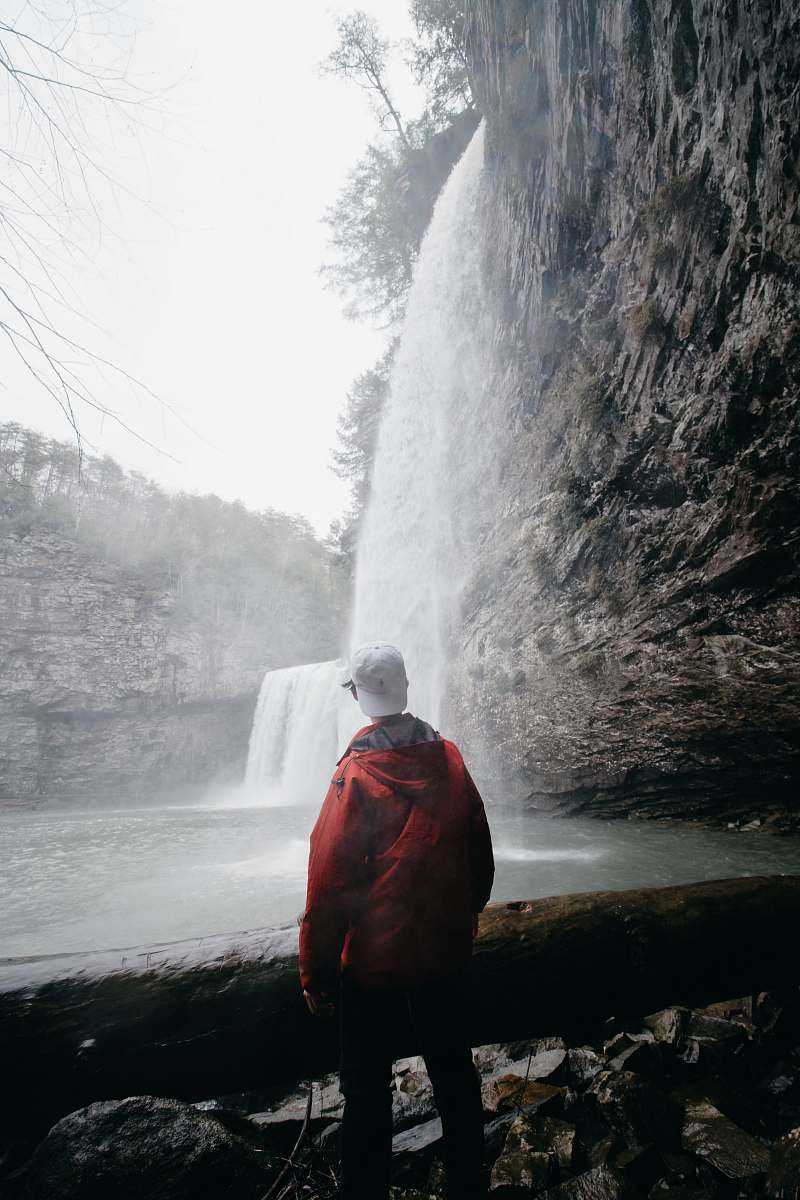 human man standing in front of waterfalls people