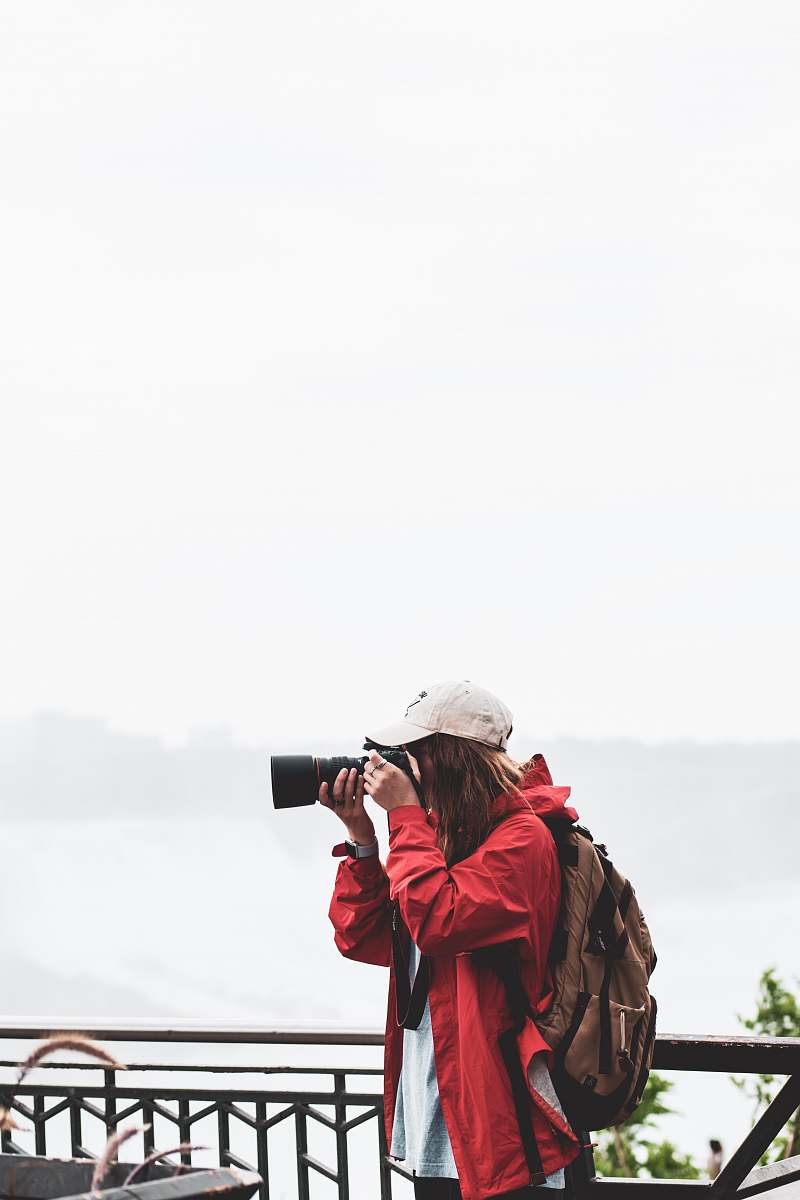 human person holding black DSLR camera taking camera shot during daytime people
