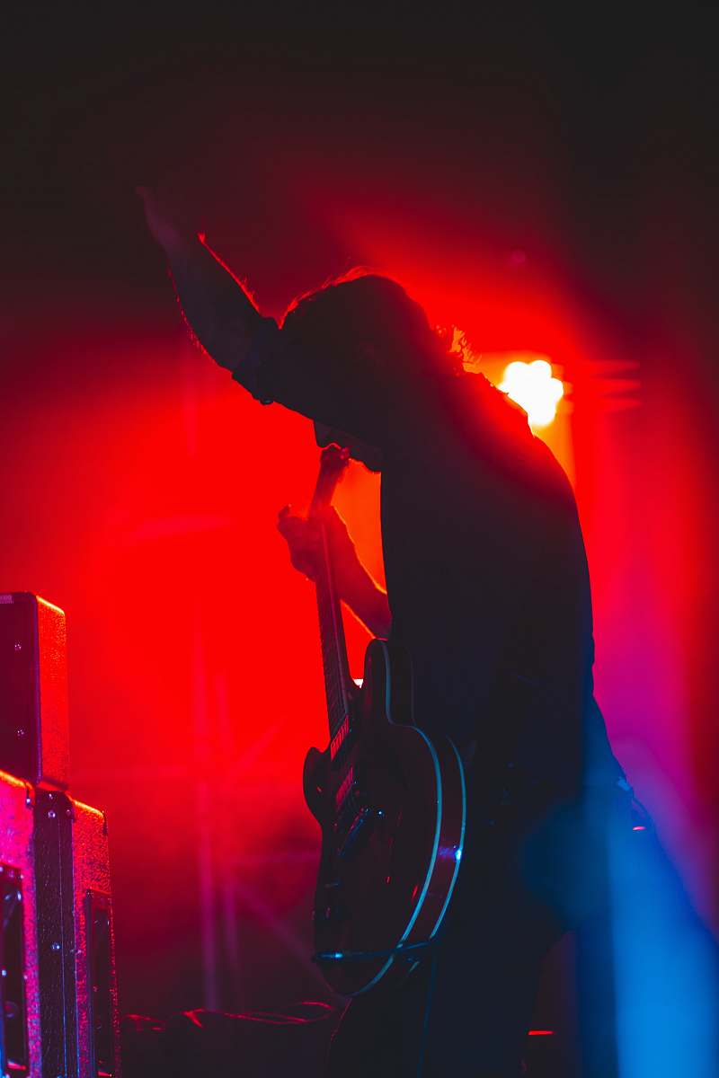 human person on stage holding guitar crowd