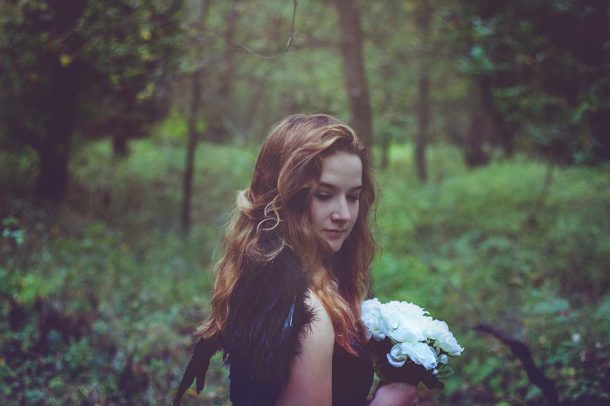 hair shallow focus photo of woman in black top holding white flowers girl