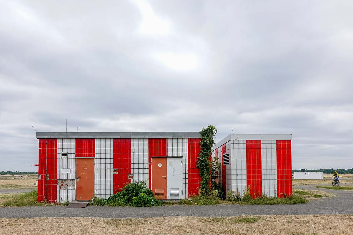 vegetation white and red striped building during daytime bush