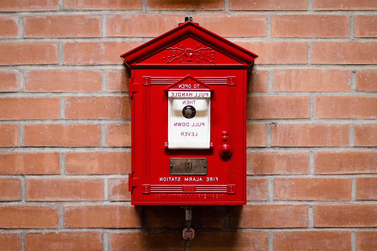mailbox red fire alarm station attached on brick wall red