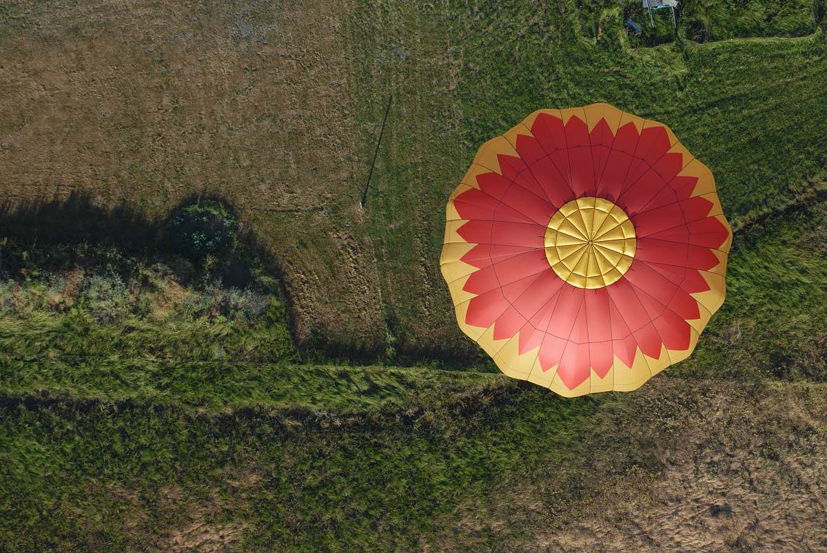 green aerial photo of hot air balloon flying in the air central point