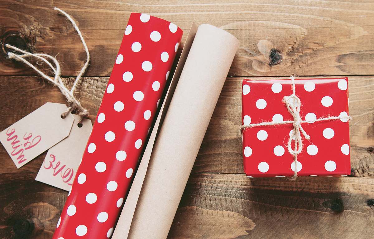 gift red and white polka-dot gift box beside gift wrappers table
