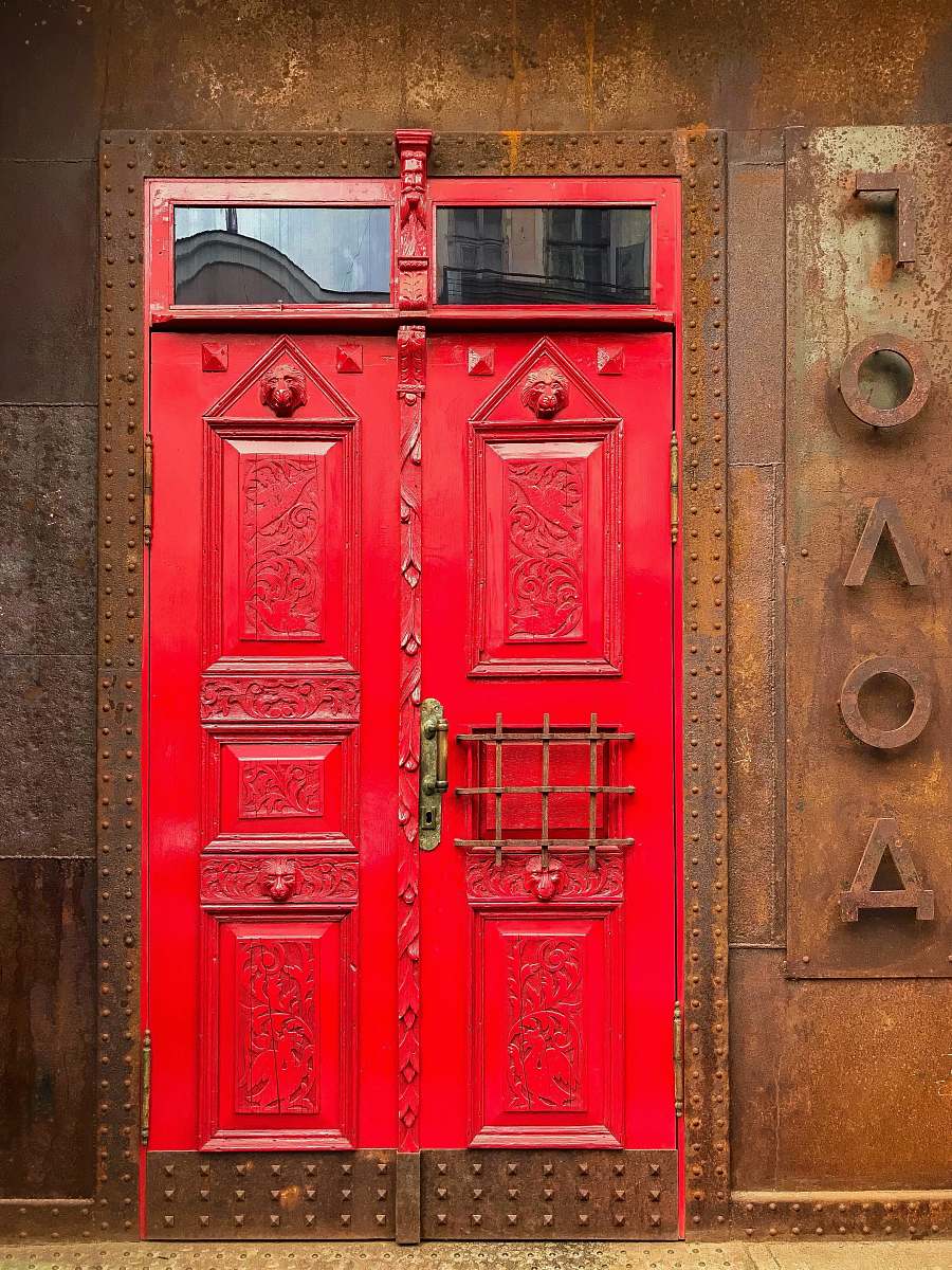 door red painted door on brown rustic metal wall path