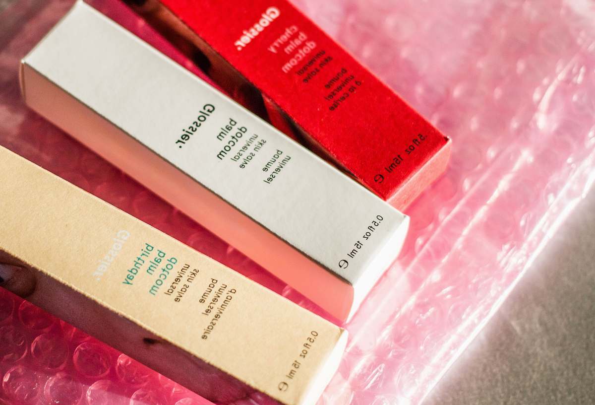 balm red, white, and brown cardboard boxes glossier