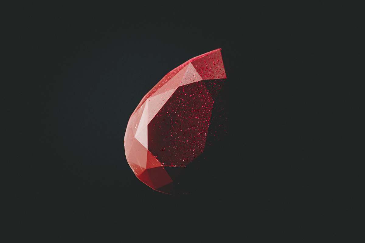 diamond selective focus photography of faceted red gemstone shape