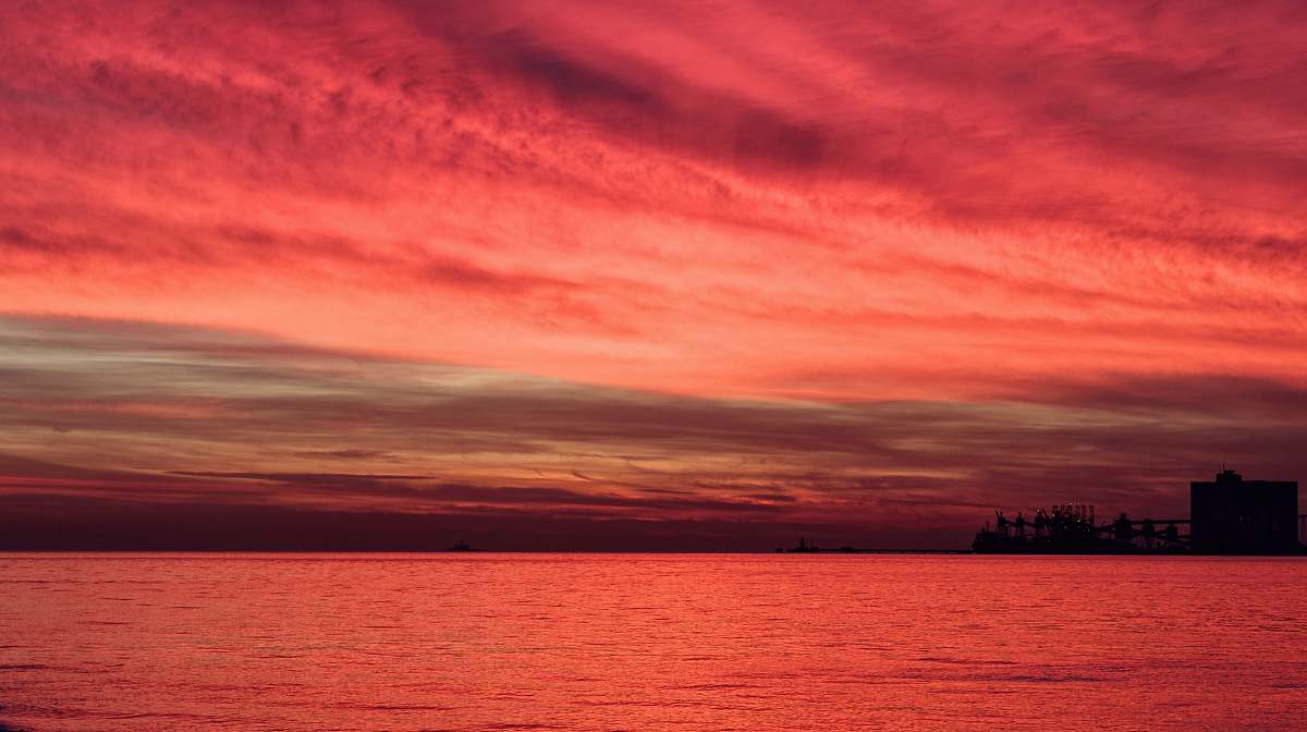 sunset silhouette of structure under red sky sunrise