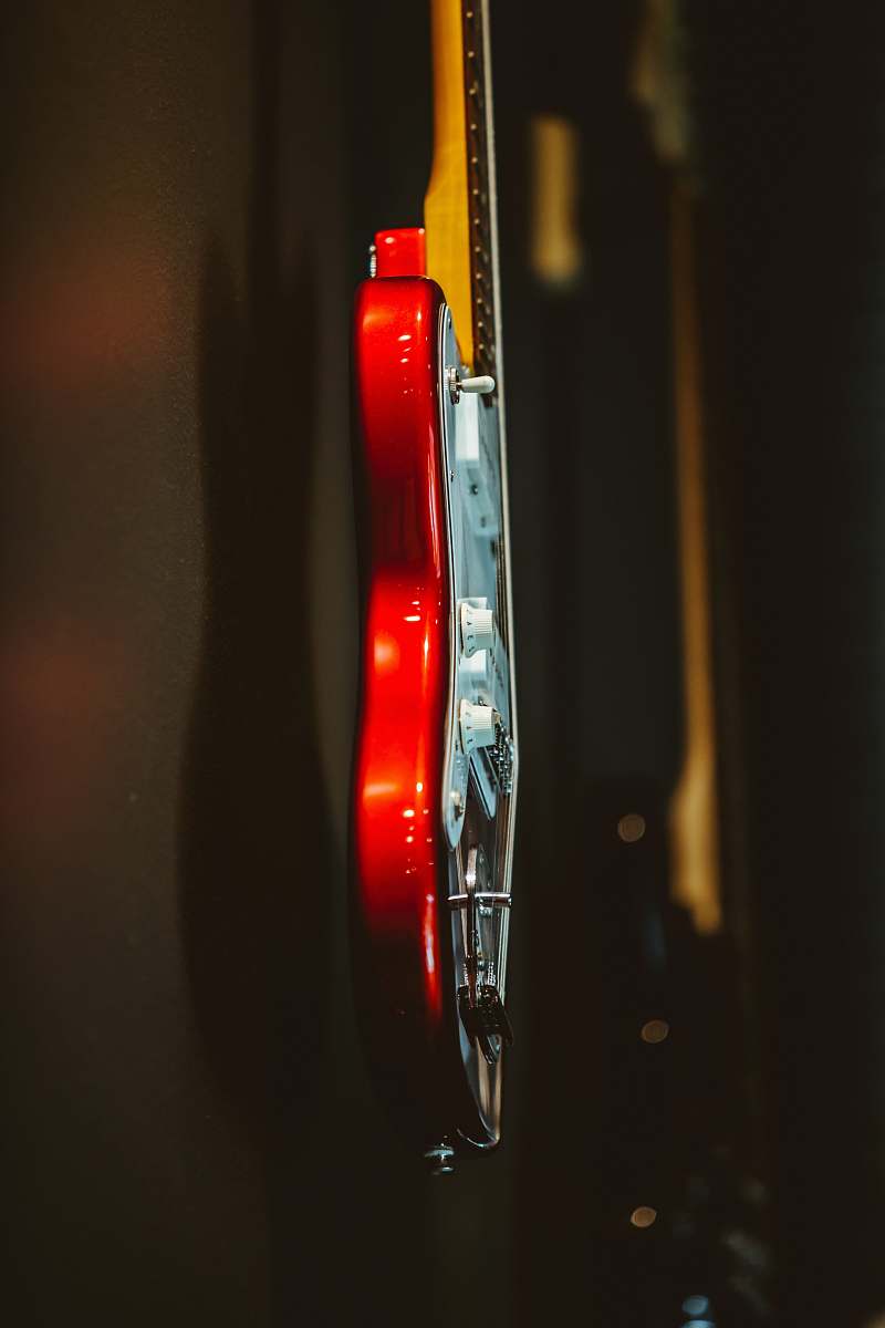 guitar white and red stratocaster electric guitar hanging on wall side view