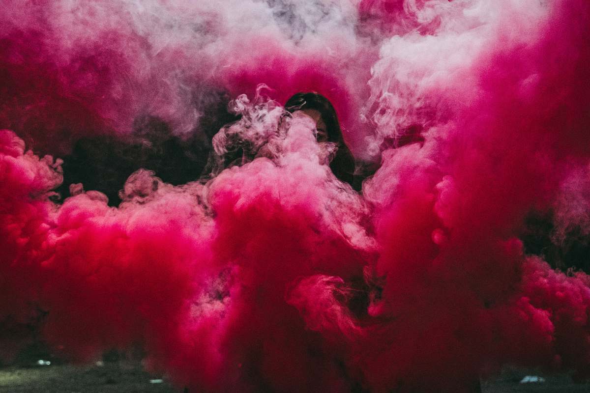 smoke woman covered with pink smoke bomb eruption