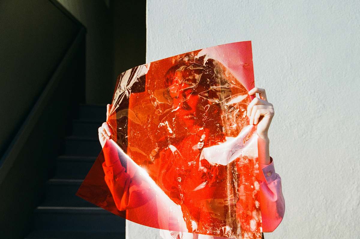 woman woman holding red film beside wall female