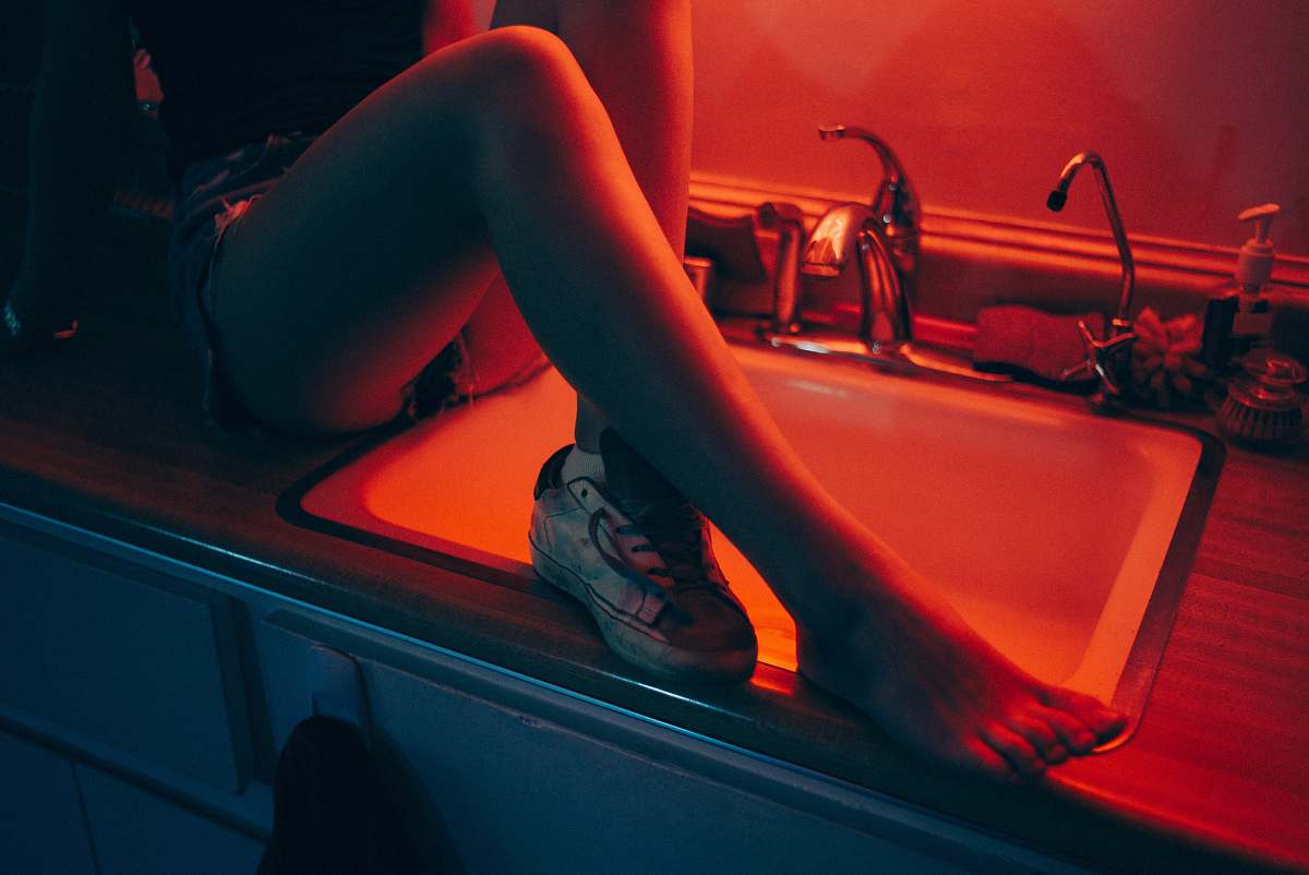 leg woman sitting on sink top inside room sink